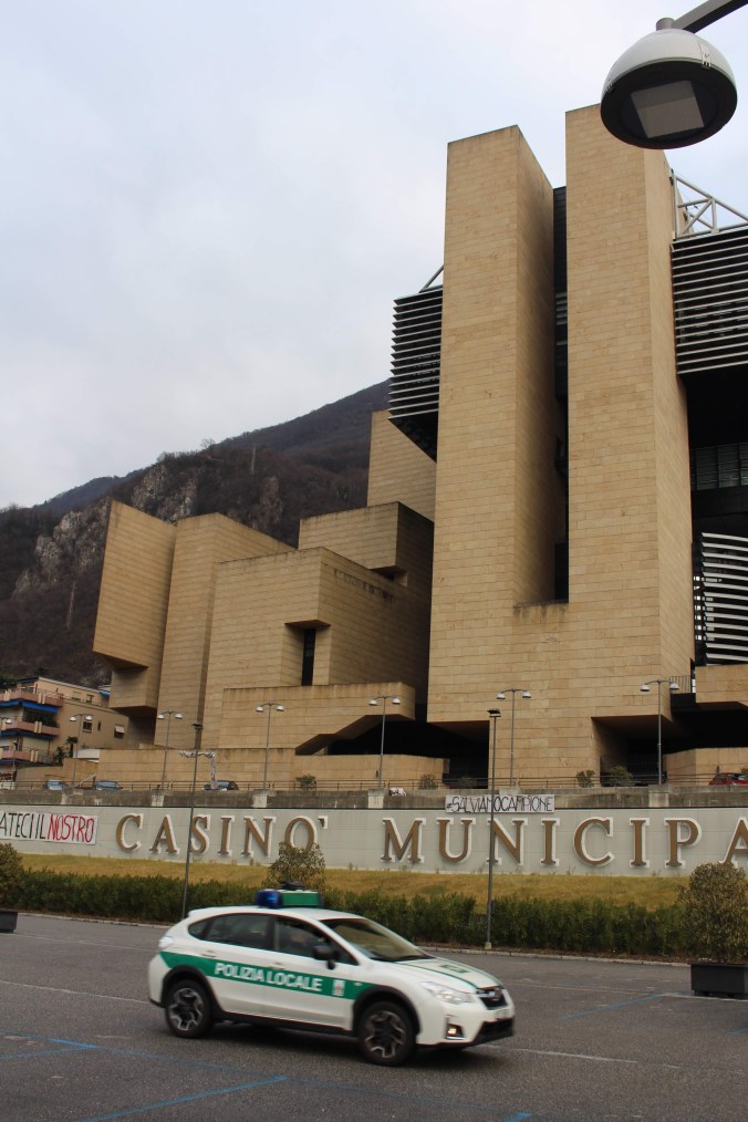 Italian police car passing in front of the now-shuttered casino in Campione d'Italia